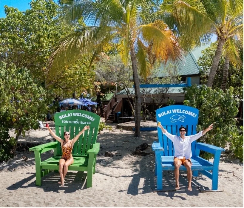 南国のビーチで巨大な椅子に座るカップル