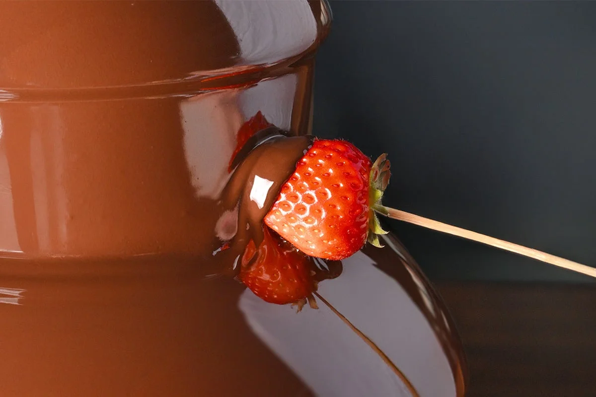 チョコレートファウンテンにディップされるいちご