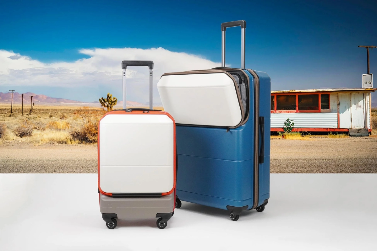 広々とした砂漠の風景を背景に、大小2つのモダンなデザインのスーツケース