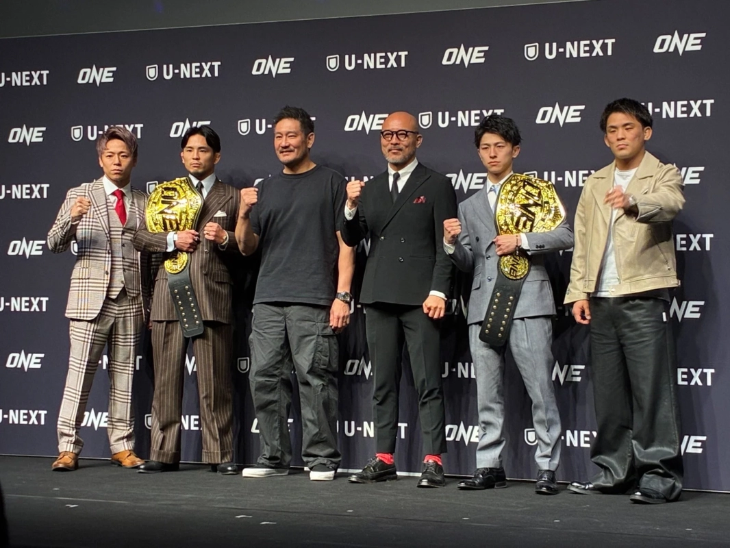 ONE ChampionshipとU-NEXTのロゴが並ぶステージに立つ男性たち